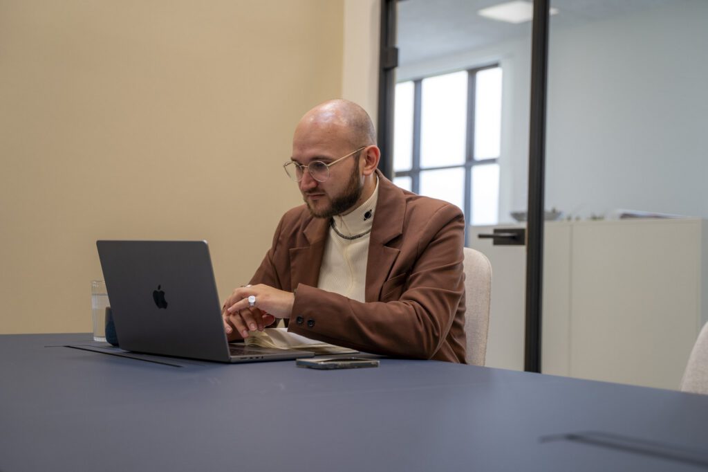 Medarbejder arbejder på laptop i et mødelokale hos MEDIAPOINT