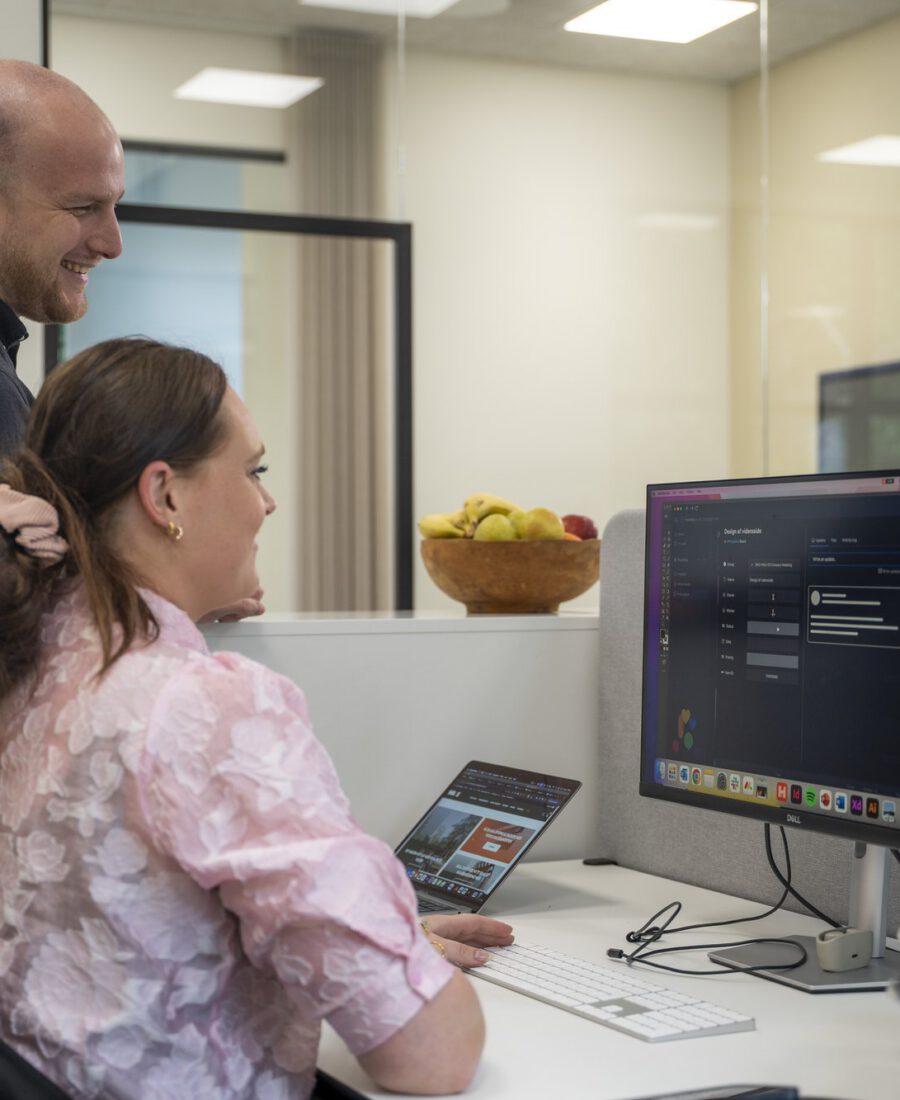 To kollegaer gennemgår tal på en skærm hos MEDIAPOINT