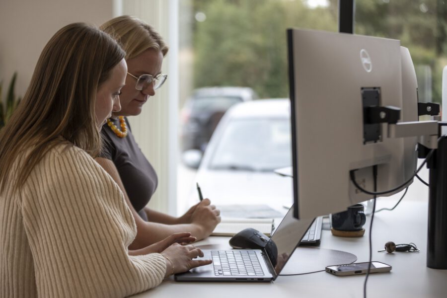 To kollegaer arbejder sammen ved skærmen hos MEDIAPOINT