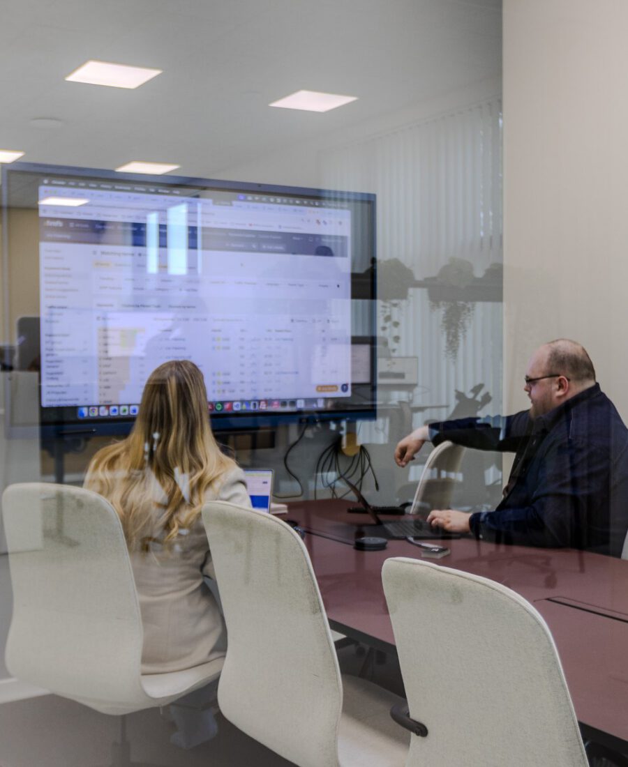 To kollegaer gennemgår søgeordsdata på storskærmen i mødelokalet hos MEDIAPOINT